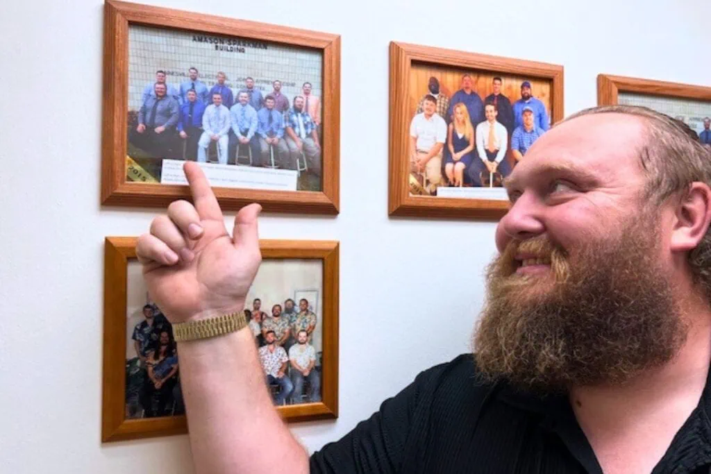 Trevor Chapman points to where he is pictured in the 2015 graduating class photo that hangs on the wall in the Electrical Training Alliance of Gainesville office. Photo by Nick Anschultz