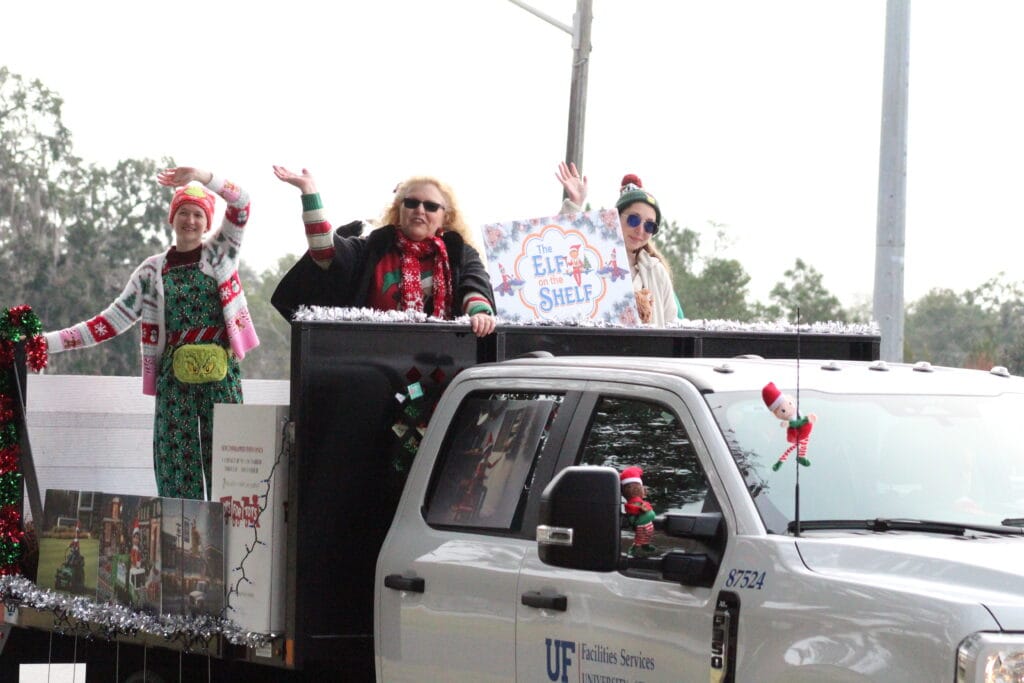 UF Facilities Services employees wave to spectators during the Children's Christmas Parade (Photo by Nick Anschultz)