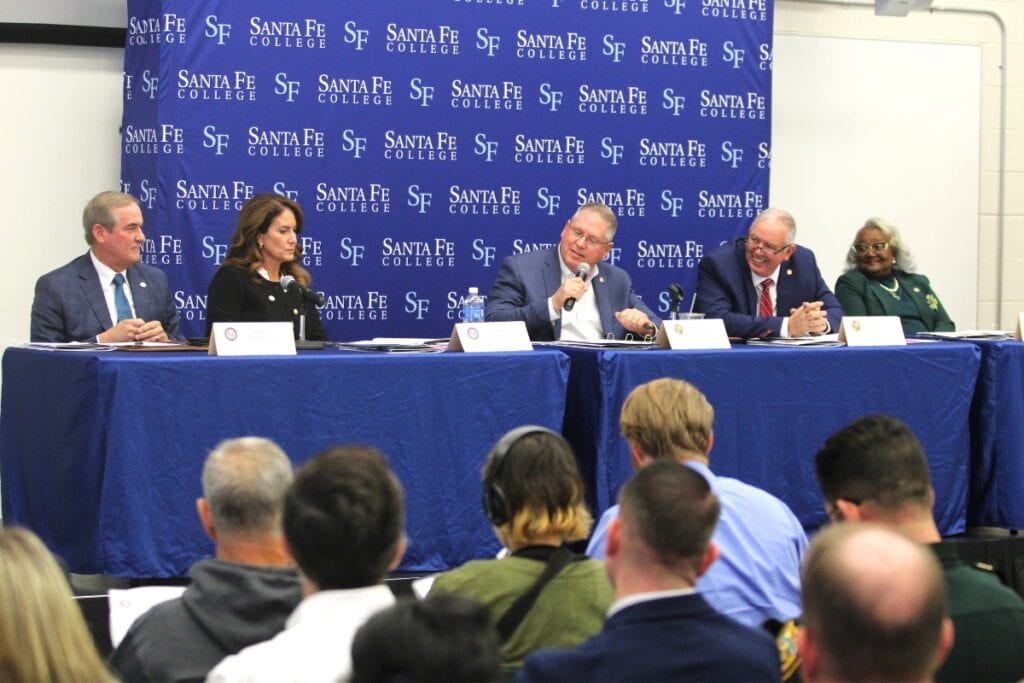 Alachua County's legislative delegation sits behind the dais at a meeting in Gainesville.