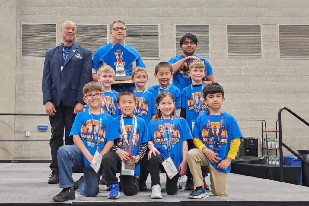 Oak Hall's first grade chess team. From left to right, Tanner Samant, Leon Wu, Miyuki Phillips and Joseph Aghdashi in the front row; Lincoln Laconi, Santiago McMillen, Sam Li and Levi Merkel in the middle row; President of US Chess Kevin Pryor, Oak Hall Head Coach Tim Tusing and Oak Hall Assistant Coach Ayush Maddikonda.
