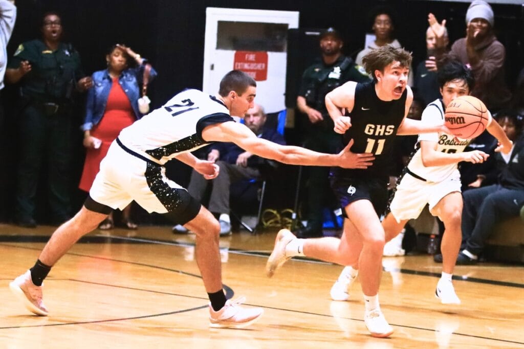 Buchholz's Gabe Williams (21) fouls Gainesville's Kyle Pinter (11) with 5.2 seconds left in overtime, helping the Hurricanes with a 38-36 road win. Photo by C.J. Gish