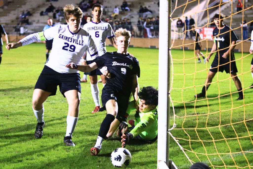 Buchholz's Teague McNeal (9) tries to score against Gainesville goalkeeper Carlos Morales Garcia (20). Photo by C.J. Gish