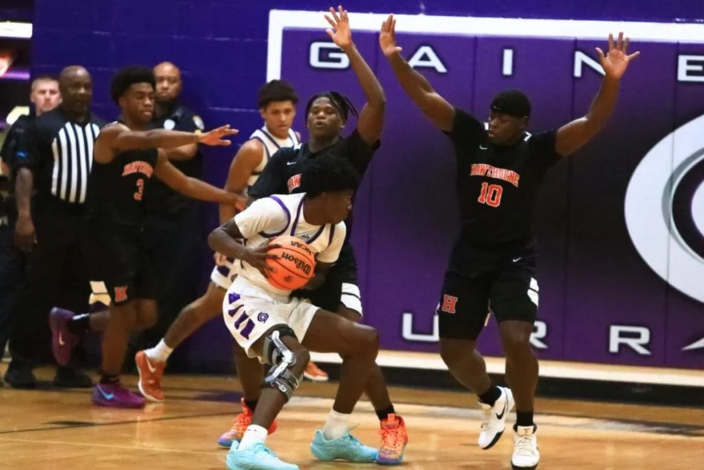 Gainesville's Craig Thomas Jr. (4) defended by Hawthorne's Nathan Jennings (2) and Kyler Ingram (10). Photo by C.J. Gish 1 (1)