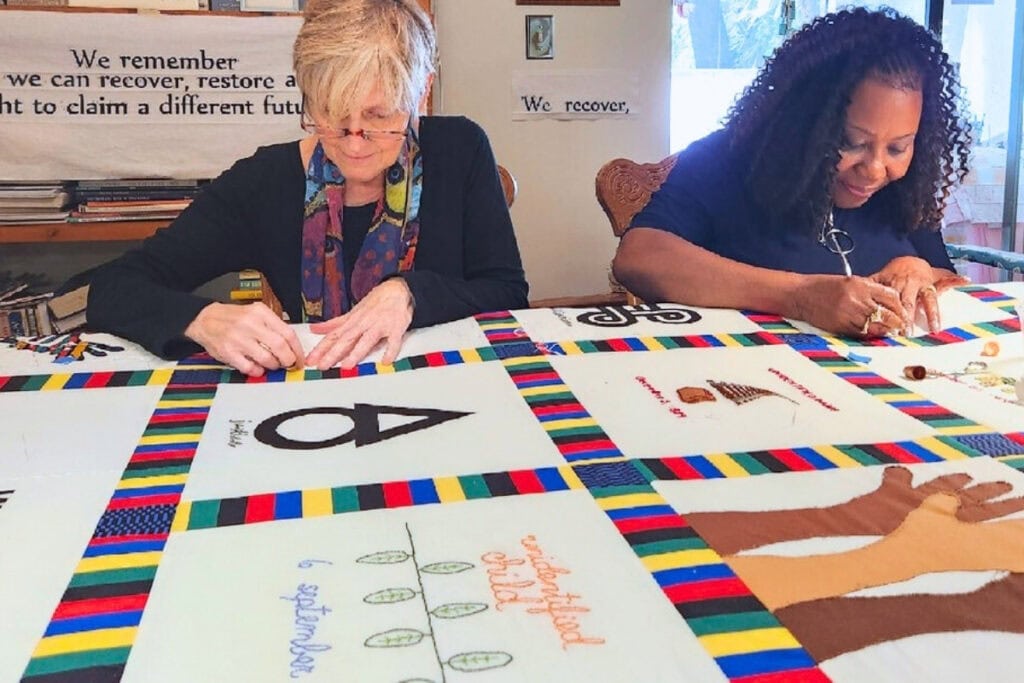 The Alachua County Community Remembrance Project will host its grand opening of the Remembrance Quilt Exhibition on Tuesday, Jan. 21, at the Matheson History Museum. two women working on a quilt.