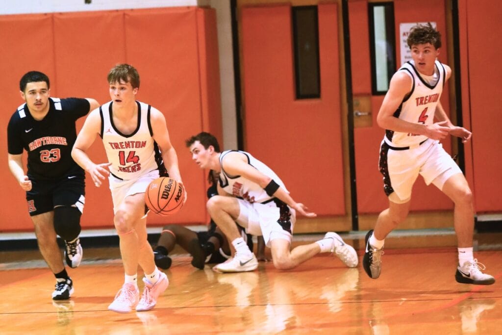 Trenton's Tyler Bullis (14) pushes the ball down the court against Hawthorne. Photo by C.J. Gish