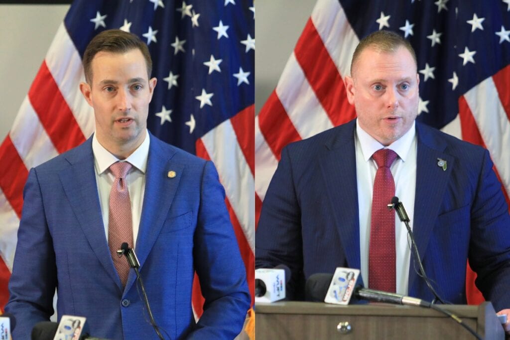 United States Attorney John Heekin (left) and FBI Special Agent in Charge Jason Carley at a podium to announce a sentencing for fraud.