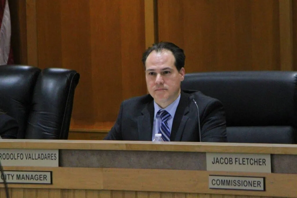 Rodolfo Valladares listens to the City Commission vote him in as permanent city manager during a regular meeting.