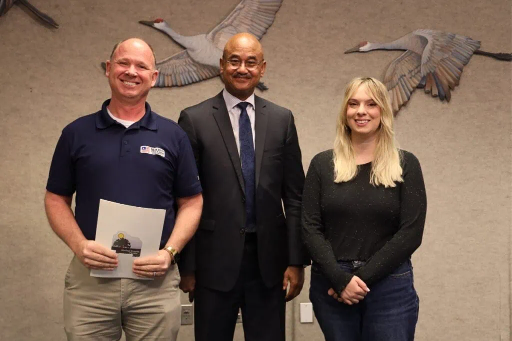 From left, Senior Editor C.J. Gish, County Commissioner Chuck Chestnut IV and Member Ambassador Natalie Mitchell participated in the county's proclamation declaring March 2-9 as Newspaper in Education Week.