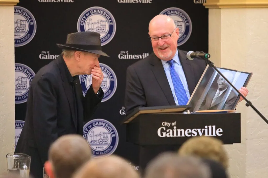 Mayor Harvey Ward presents Benmont Tench with a framed photo of his grandfather, Benjamin Tench, who served as a mayor of Gainesville in the early 1900s. Photo by Seth Johnson