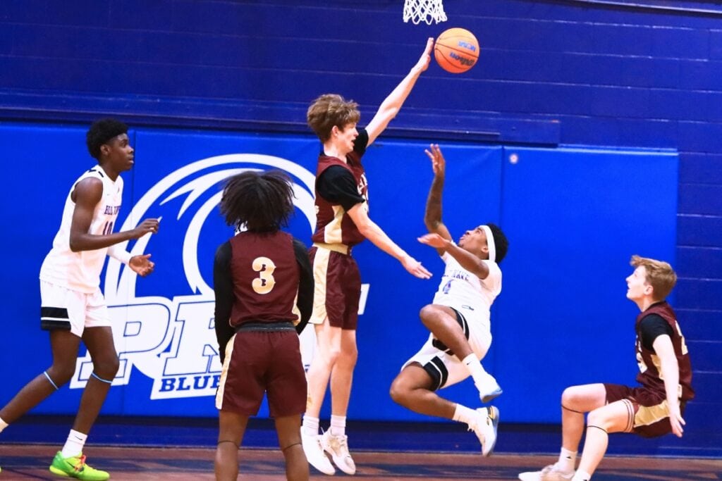 P.K. Yonge's Decedric Sowell (4) puts up an off-balance shot against Oak Hall's Elijah Medved (32) in the Class 2A-District 2 Semifinals. Photo by C.J. Gish