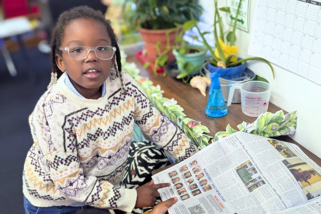 Second grader Khamile Carter uses a Mainstreet Daily News print edition during the school day with Newspaper in Education program. Courtesy of Mary Thomas - Caring and Sharing Learning School