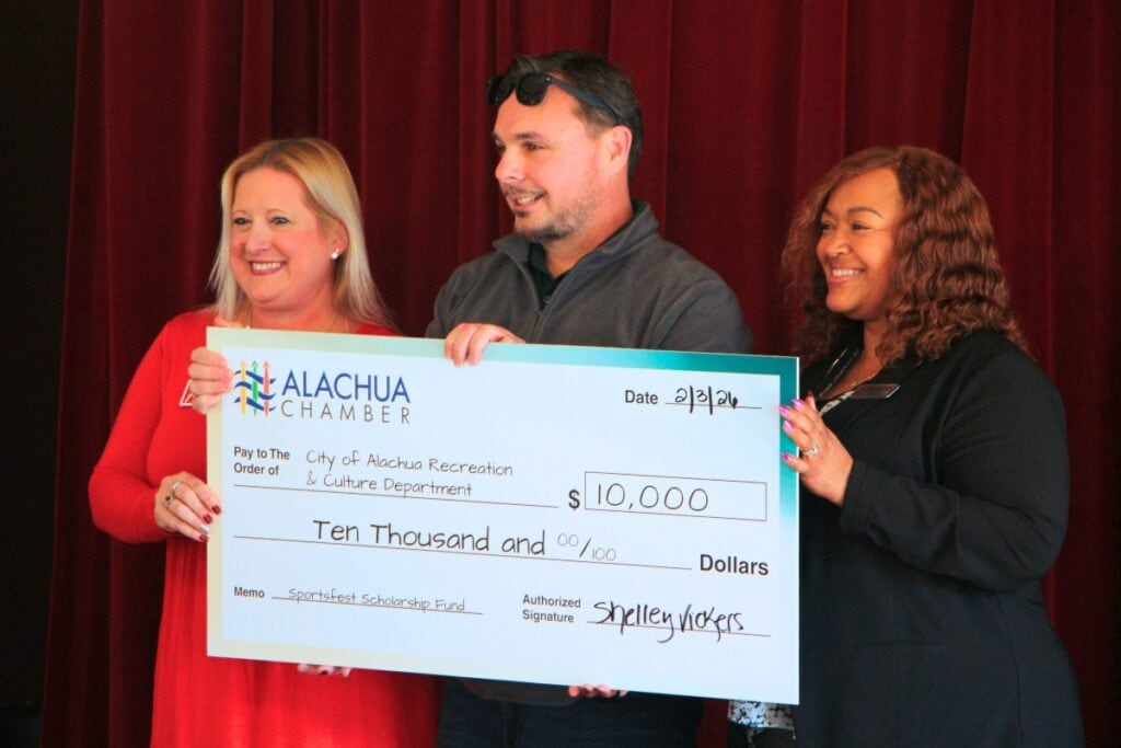 Shelley Vickers (left) gives representatives from the City of Alachua a $10,000 grant to provide Recreation & Culture to low-income families. Photo by Lillian Hamman