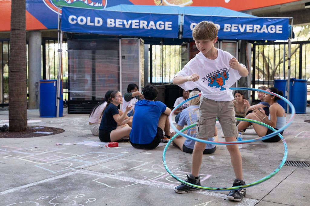 A boy demonstrates his hula hooping skills at a fun zone set up by volunteers from Alpha Epsilon Delta, a pre-health honors society at the University of Florida.