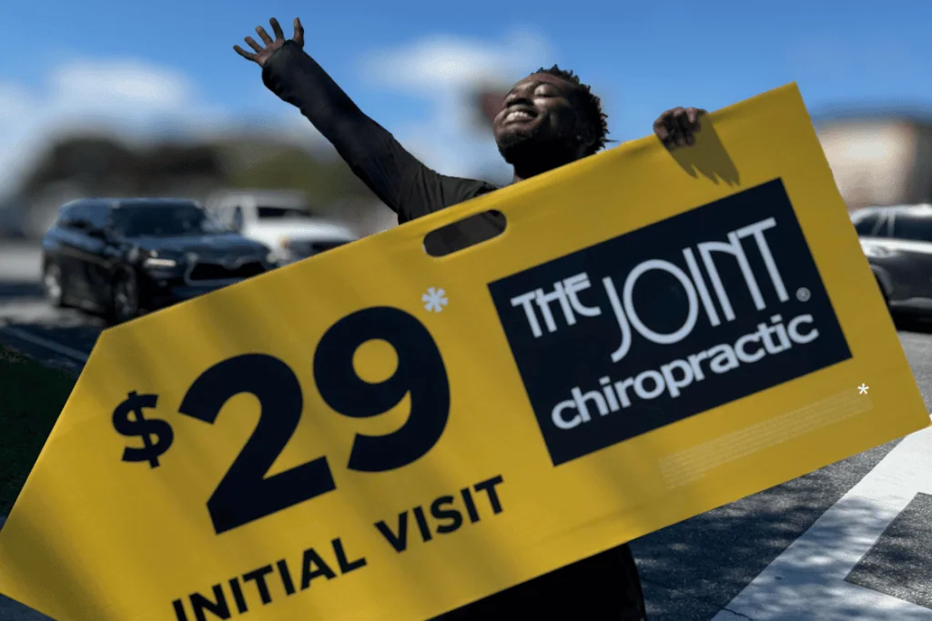 the Joint Chiropractic sign spinner