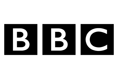 A person using a zimmer frame is assisted by another standing person. Both are shown in a simple black-and-white line drawing.