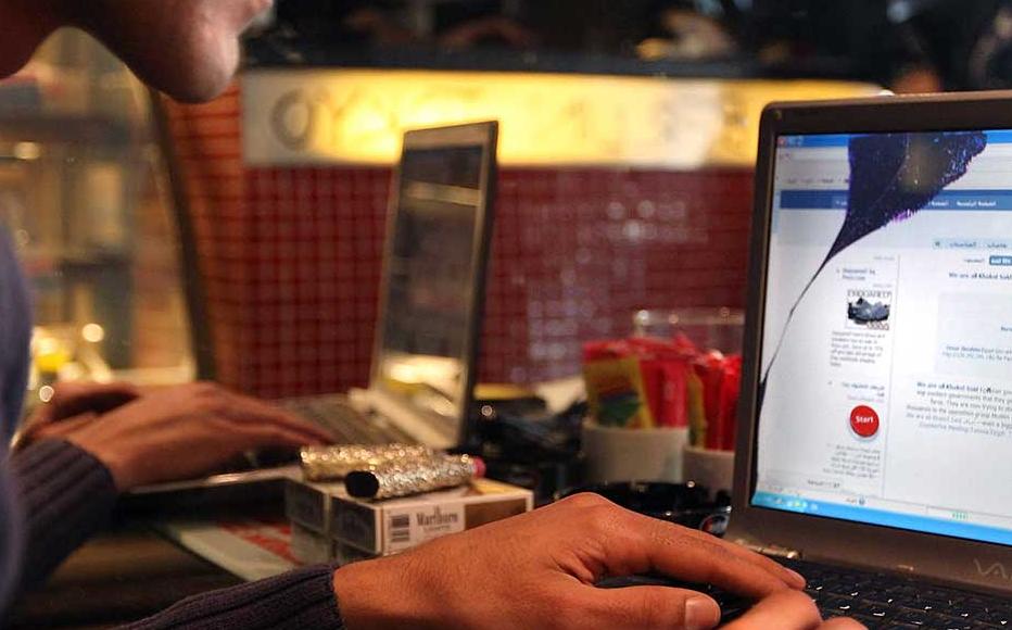 A man looks at a laptop computer displaying Facebook in a cafe on January 27, 2011 as anti government protesters take to the streets in Cairo, Egypt.