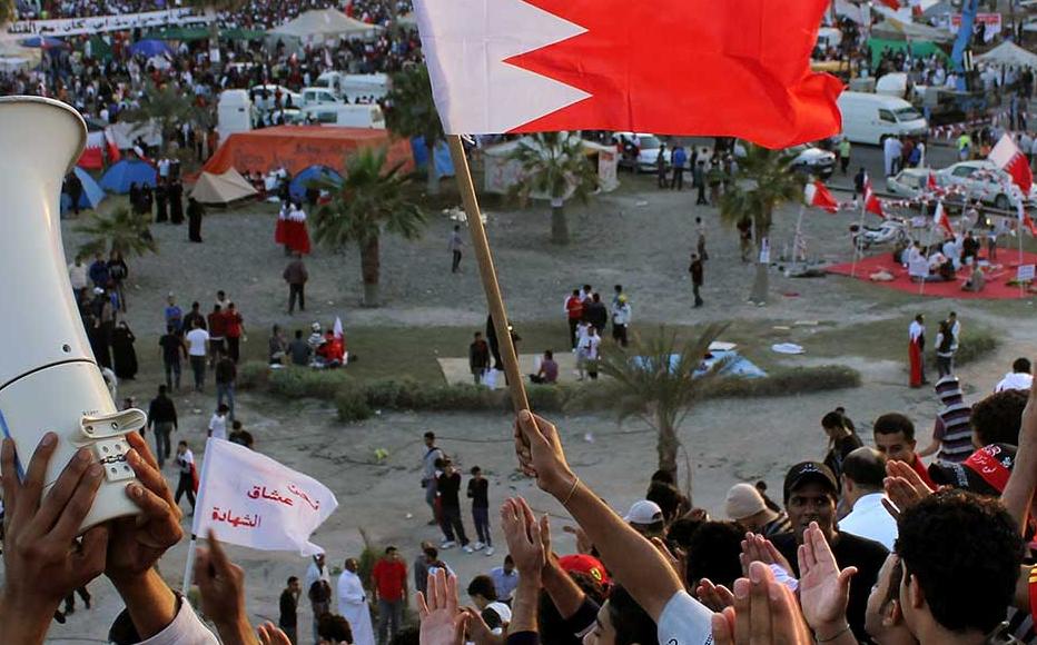 Anti-government protesters wave flags and demonstrate at Pearl Roundabout on February 20, 2011 in Manama, Bahrain.