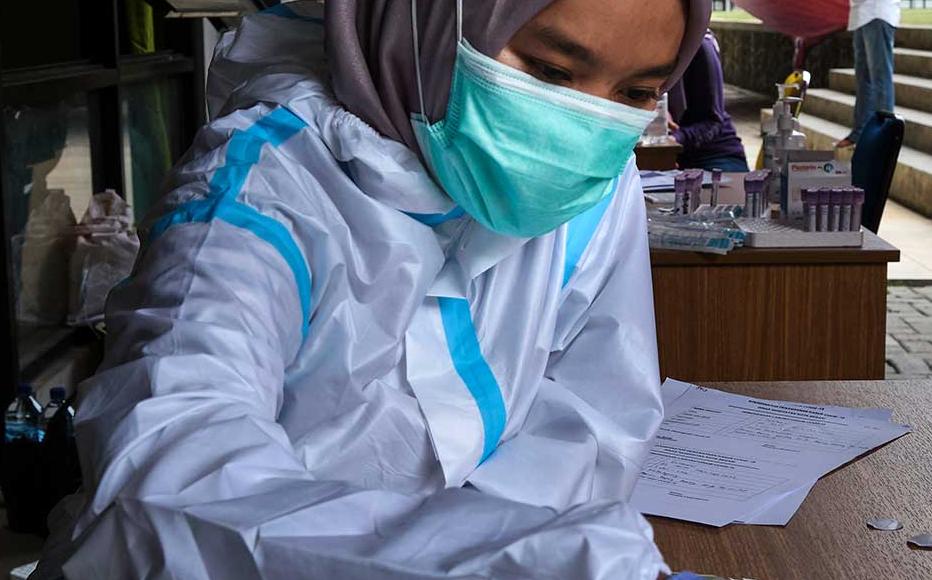 An Indonesian nurse works with a rapid test for the Covid-19 Coronavirus at a football stadium which was used as a hospital for Covid-19 patients.