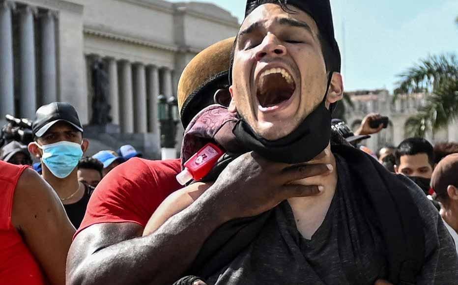 A man is arrested during a demonstration against the government of Cuban President Miguel Diaz-Canel in Havana, on July 11, 2021. - Thousands of Cubans took part in rare protests Sunday against the communist government, marching through a town chanting "Down with the dictatorship" and "We want liberty."