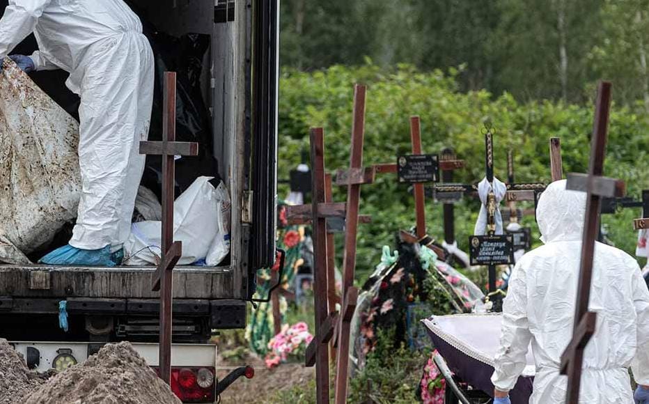 Workers placing a body of one of the unidentified persons who were killed during the Russian occupation of Bucha into a coffin on August 11, 2022 in Bucha, Ukraine.