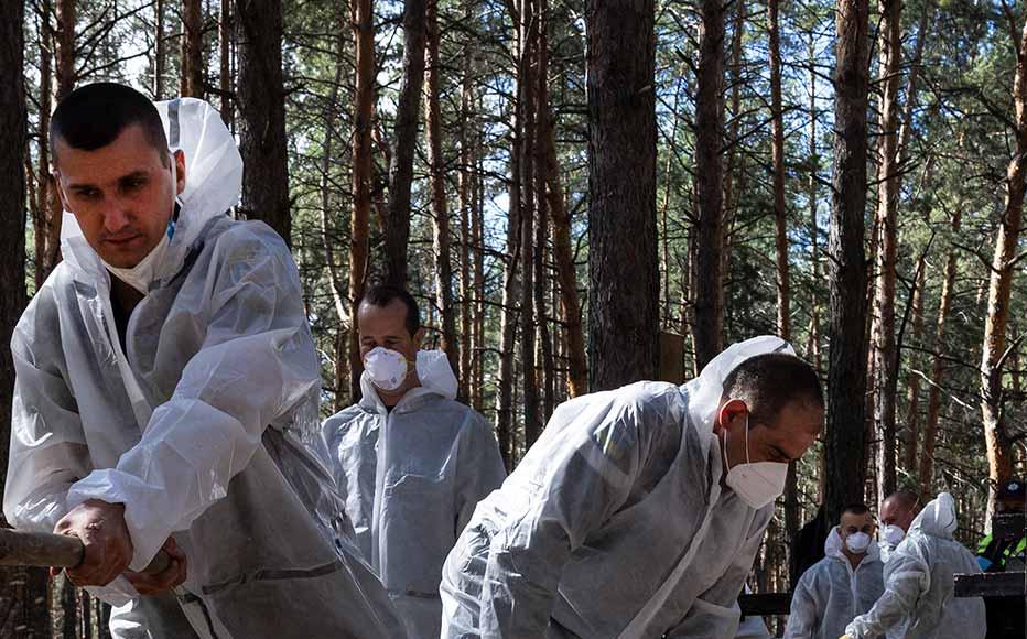 Forensics exhume bodies from unidentified makeshift graves at the Pishanske cemetery on September 19, 2022 in Izium, Ukraine.