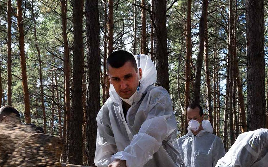 Rescue workers and forensic police exhume bodies from unidentified makeshift graves at the Pishanske cemetery on September 19, 2022 in Izium, Ukraine. The bodies will be examined by forensic officials for possible war crimes. Izium was recently liberated from Russian occupation after six months. Approximately 440 bodies are buried at the cemetery, so far 161 bodies have been exhumed, taken to the morgue in Kharkiv.