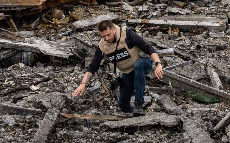 Journalists visit the site of a destroyed Russian munitions depot in Biskvitne, Ukraine to the east of Kharkiv.