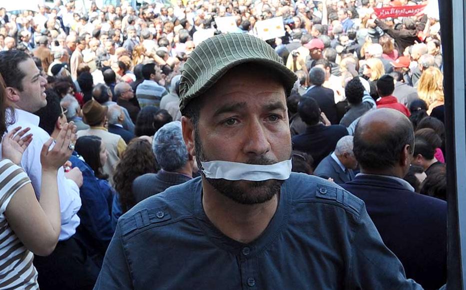 A Tunisian journalist holds a TV frame on April 25, 2012 during a sit-in outside the municipal theatre in Tunis to protesting silencing Tunisian Television journalists.