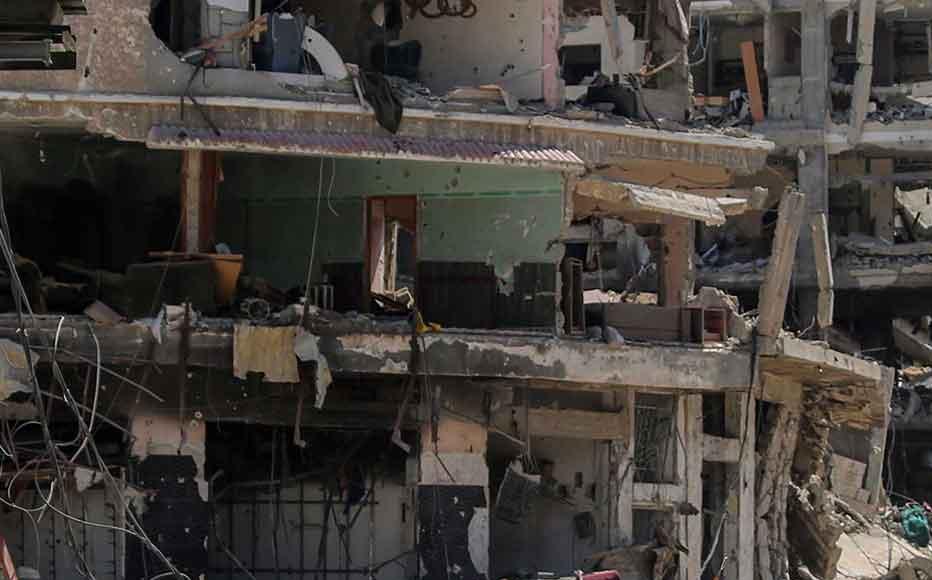 A man carries items on a bicycle while walking next to a woman as people remove possessions and inspect their homes following Israeli airstrikes on April 13, 2024 in Khan Yunis, Gaza.