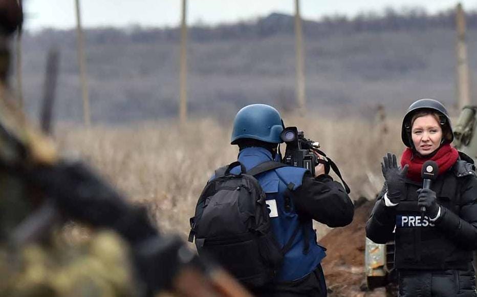 A TV journalist prepares to do a piece to camera in front of an armoured personnel carrier on the frontline between Ukrainian forces and pro Russian separatists near the eastern Ukrainian city of Debaltseve, in the Donetsk region on 24, 2014.