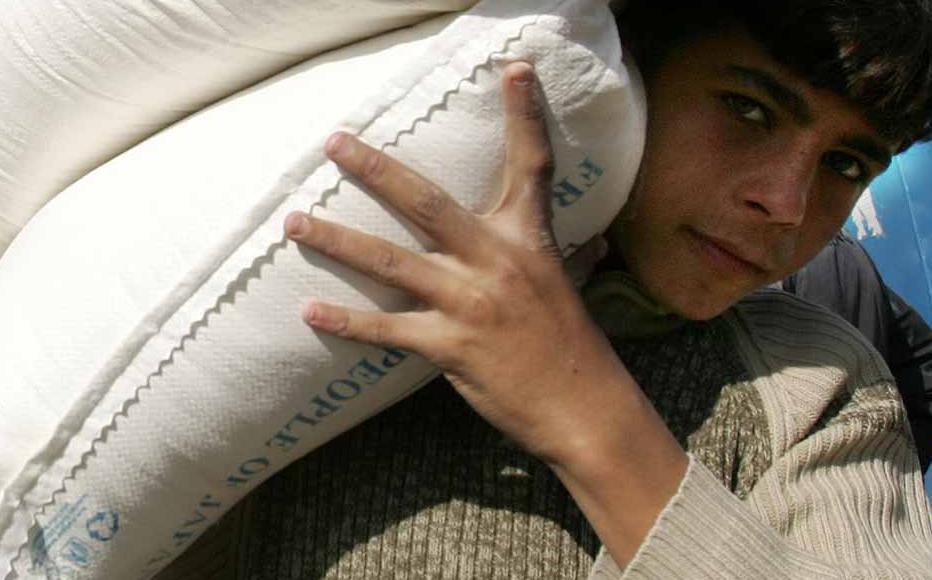 A Palestinian boy is seen carrying food aid from the United Nations Relief and Works Agency (UNRWA) in al-Shati refugee camp on January 13, 2009, in Gaza City.
