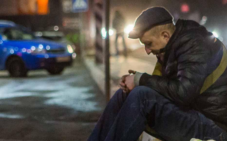 man sits in a parking lot in front of a closed shopping centre in Irpin, a town just beyond Kyiv’s city boundaries. (February 24, 2022)