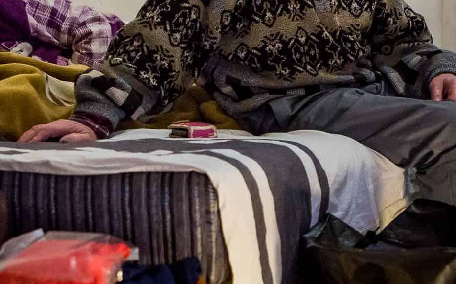 Valery Fedulkin and Galina Fedulkina fled from Donetsk to Irpin in 2016 as they wanted to live away from the conflict. They lie on the bed near their “go” bags. (February 24, 2022)