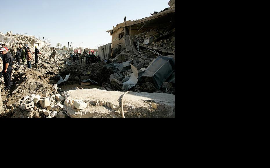 Rescue workers and members of the security forces sift through the rubble of a devastating car bomb that targeted a police station in northern Baghdad on August 25. (Photo: Metrography)