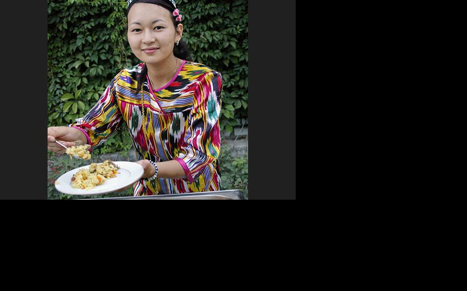 A woman is serving plov at a reception on behalf of the Uzbek Embassy in Almaty, Kazakstan. (Photo: Aziz Mamirov)