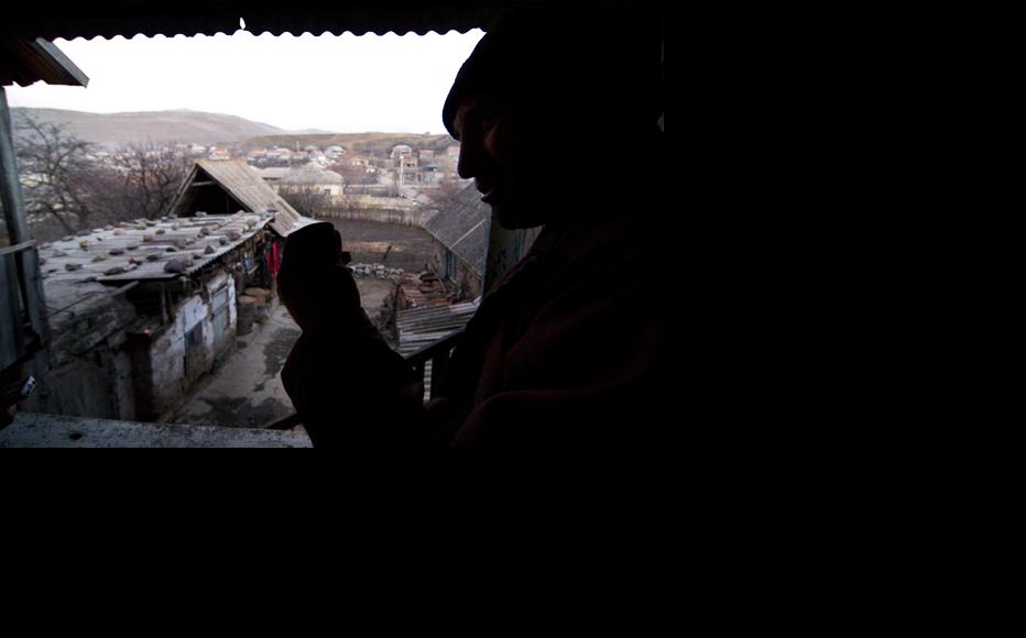 Beniamin Kirakosyan looks out on Chambarak, where many of the homes inhabited by displaced people are in desperate need of repair. (Photo: Nazik Armenakyan)