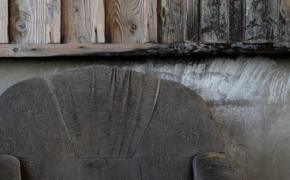 An old couch and broken watch in the hall in one of the two buildings of the Kartli complex. 