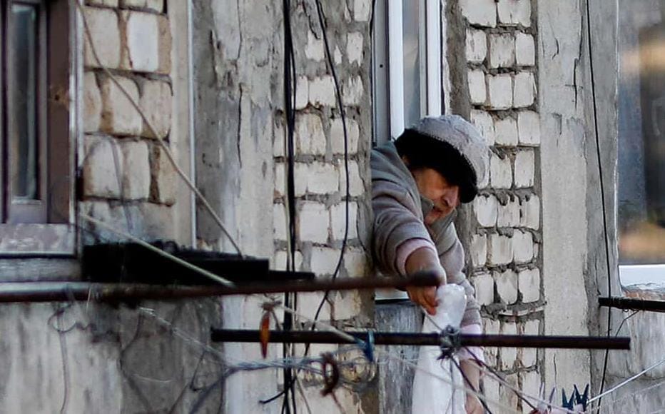 An internally displaced woman from Abkhazia hangs laundry from the window of her room in Kartli. 