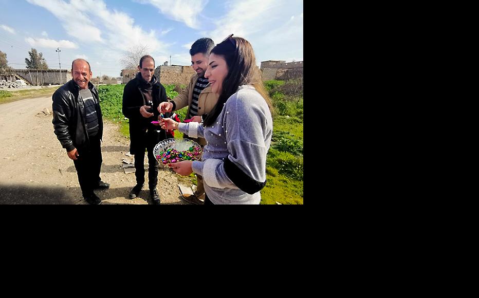 IWPR Champions Jameel and Nazek taking part in distributing messages of peace and candies on the families. (Photo: IWPR)