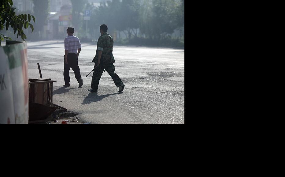 Armed men roam the streets of Osh as a pall of smoke settles over the city. (Photo: Inga Sikorskaya)