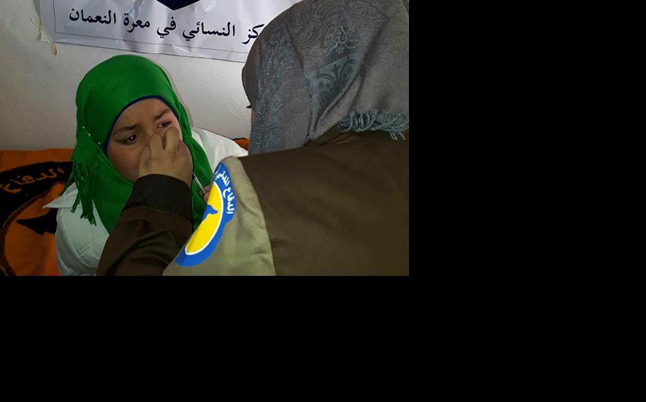 A paramedic examines a child at the Syrian civil defence centre in Maarrat al-Nu'man. (Photo: IWPR)