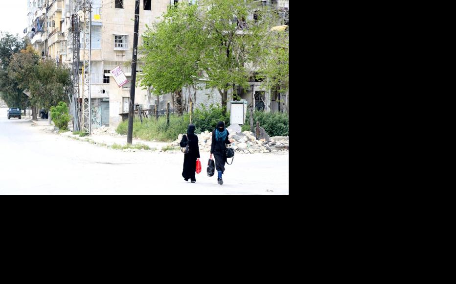 Two women walk through the al-Shaar neighbourhood. (Photo: Hussam Kuwaifatieh)