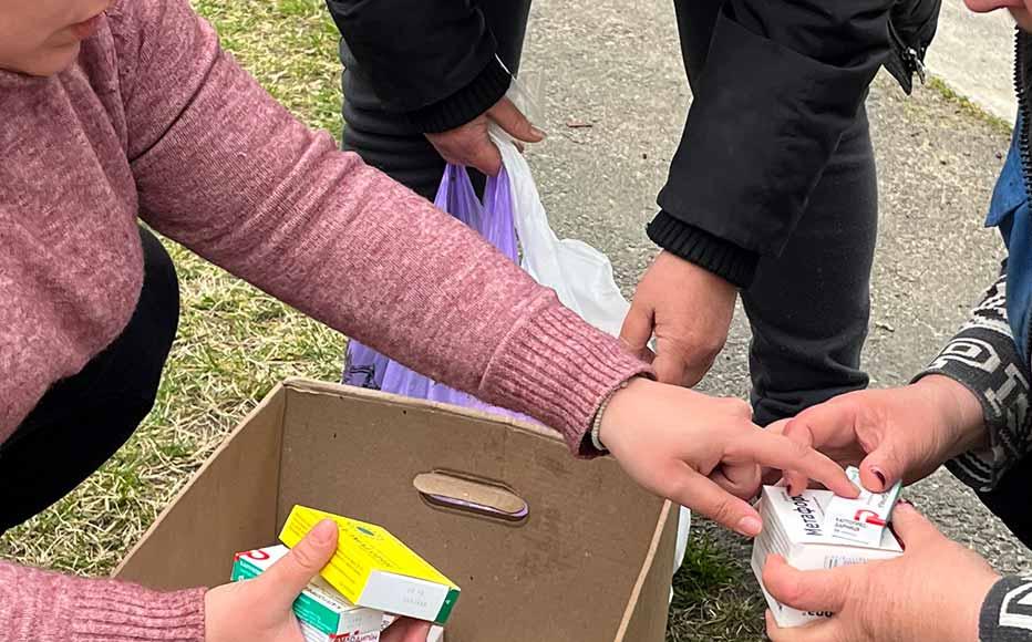 Lyudmyla Yankina (left) distributes aid in the village of Rahivka