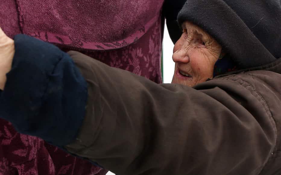 Lyudmila Kudelya, 73, hangs laundry near the ruins of her son's house, which burned down after a 120-mm mine hit their yard in February 2017. (February 3, 2022)