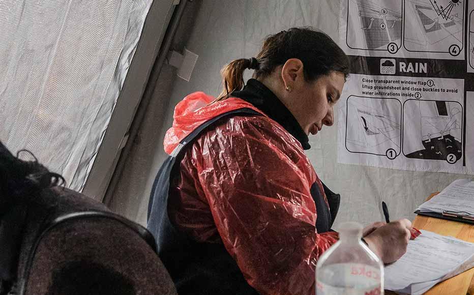 Police officers work in a tent near the mass burial site.