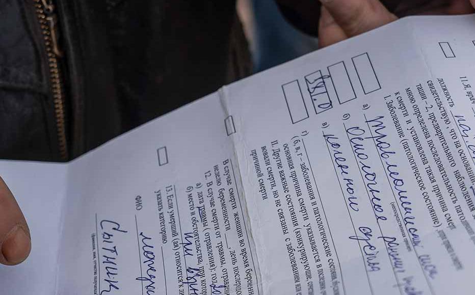 Viktor Sytnyk, 64, holds the death certificate of his mother Natalia who died on May 21. After a rocket hit their house, she was rushed to the local hospital and underwent surgery, but died following a traumatic shock.