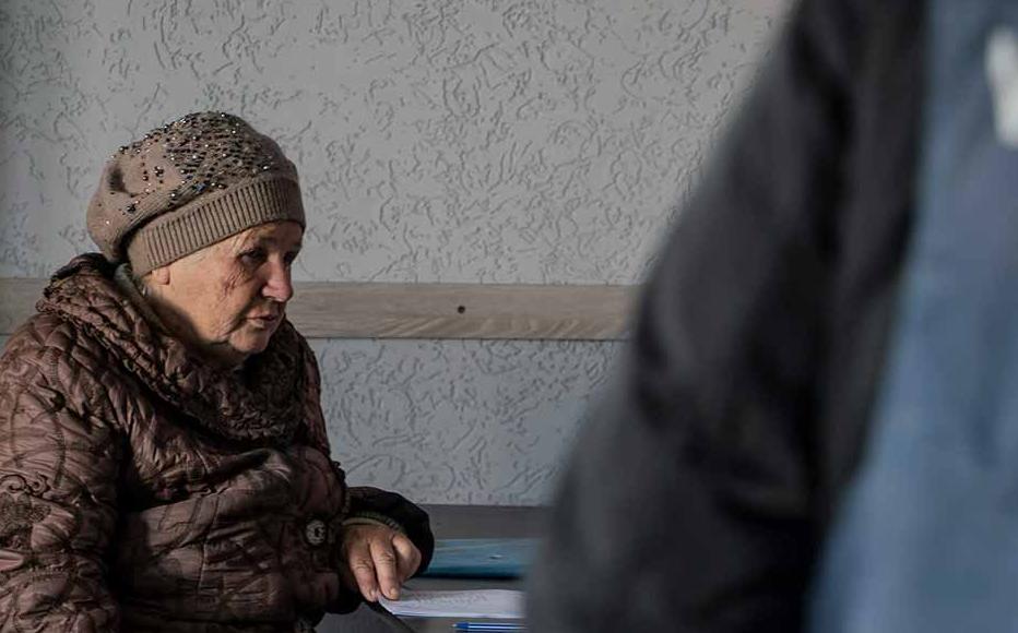 A woman sits with a prosecutor in Izyum’s makeshift police station in a former shopping centre. Residents who are trying to locate the bodies of their beloved queue to give testimonies and provide DNA samples.