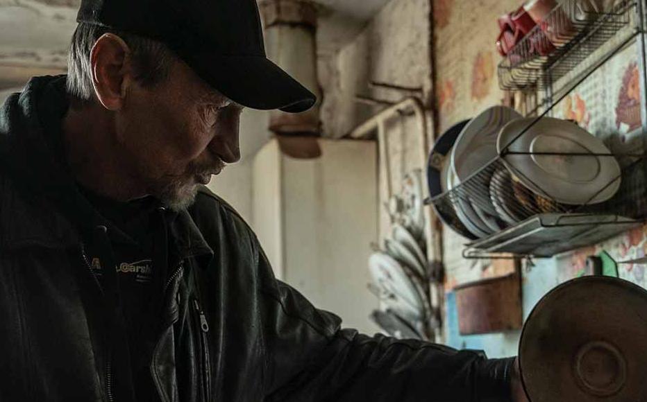 Viktor Sytnyk feeds cats in the kitchen of his house.