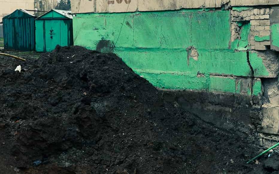 Residents of Lysychansk examine the crater from the explosion of a FAB 500 air bomb in the courtyard of a multi-storey building in mid-April.