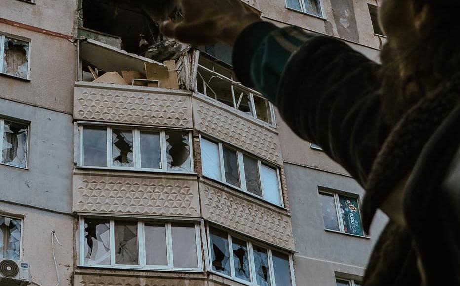 Mykhail indicates what remains of his apartment after a day of shelling. His block still stands, but little more than ash remains of many flats. (May 2022)